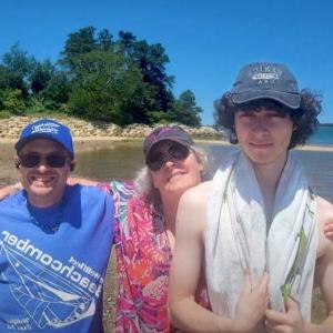 共同的生活 Living Resident poses for photo at beach with his 共同的生活 family.